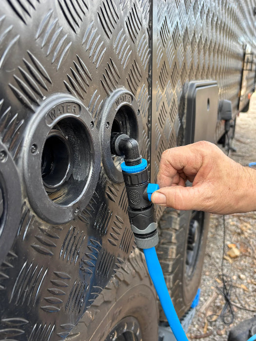 Hand opens the Navigator Tank Filler Buddy valve while filling a caravan water tank - Adventure Awaits