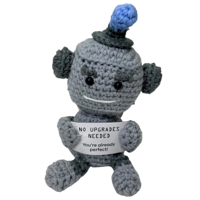 handmade crochet robot plush toy holding a motivational “No upgrades needed, you’re already perfect!” sign