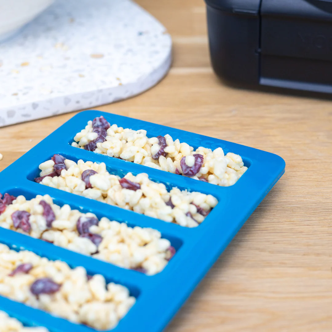 Blue silicone mold with dessert mixture on a wooden surface