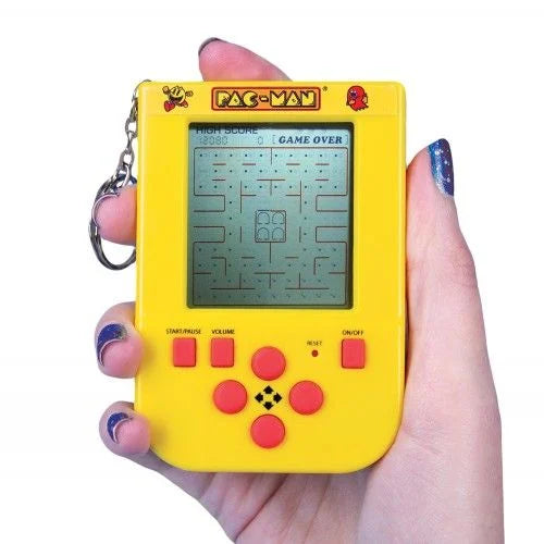 Hand holding yellow PAC-MAN Game Keyring with LCD maze screen and red controls — Adventure Awaits