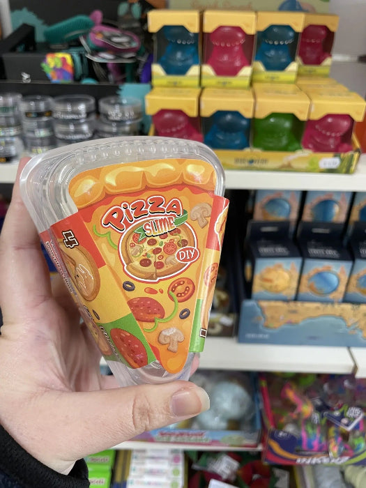 Hand holding Pizza Slime DIY sensory toy in store aisle with colourful kids toys — Adventure Awaits