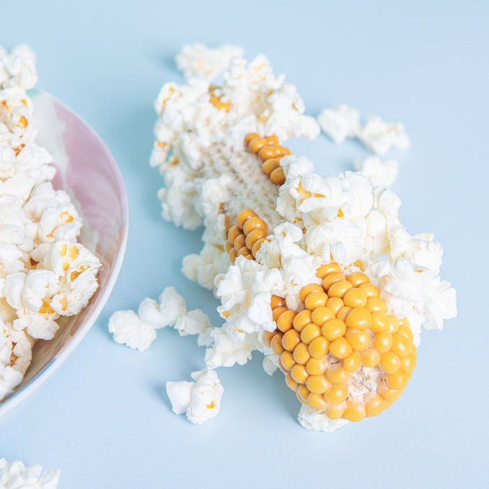partially popped corn on the cob on a blue background