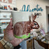 Hand holding a mug with a rabbit design against a blurred indoor background