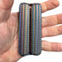 iridescent metal handheld sensory roller with textured ridges displayed in an open palm