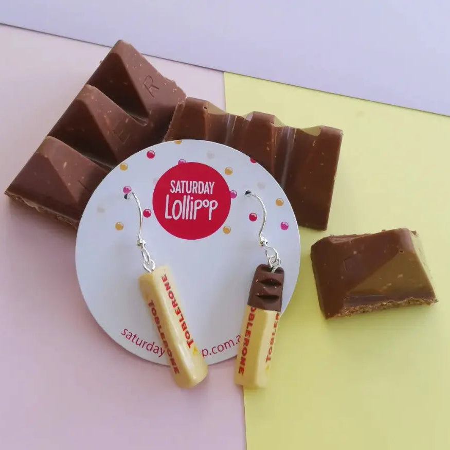 Saturday Lollipop Toblerone earrings beside chocolate pieces — Adventure Awaits