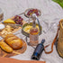 ShooAway rechargeable fly repeller on picnic bottle beside cheese and bread — Adventure Awaits