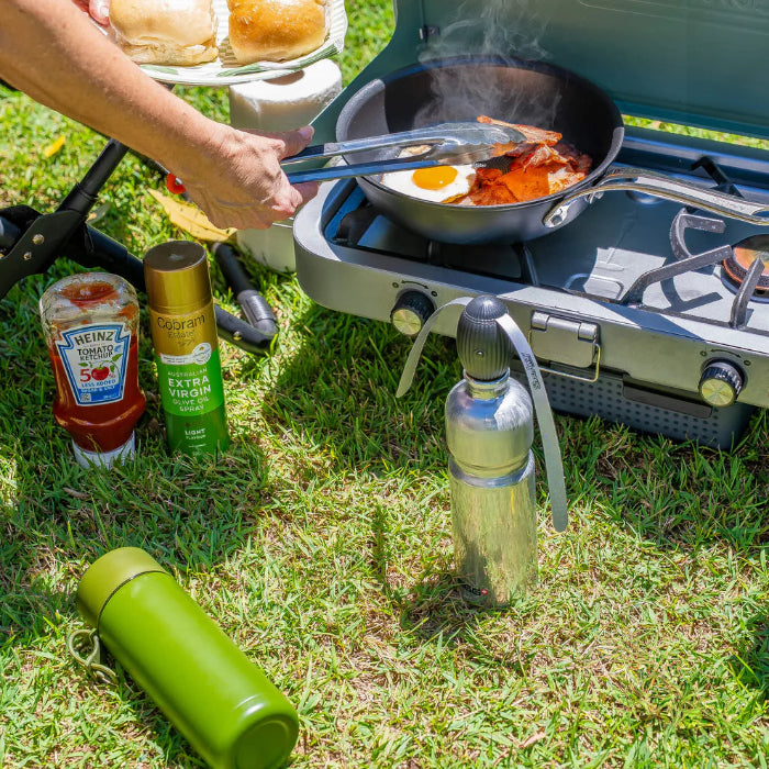 ShooAway rechargeable fly repeller on bottle beside camp stove cooking breakfast — Adventure Awaits