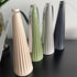 Four ribbed portable lanterns in cream, green, white and charcoal on black table — Adventure Awaits