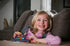 Child playing Smart Games IQ Fit logic game on the couch with colourful pieces — Adventure Awaits