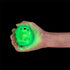 Hand holding a glowing green echidna squishy sensory toy against a black background