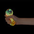 Hand squeezing orange glow in the dark ball squishy toy against black background — Adventure Awaits
