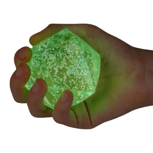 Hand squeezing green glow in the dark diamond squishy toy with glitter finish — Adventure Awaits