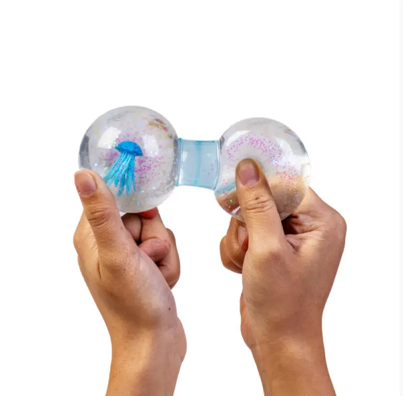 Hands squeezing blue jellyfish glitter water sensory toy for kids calming play — Adventure Awaits