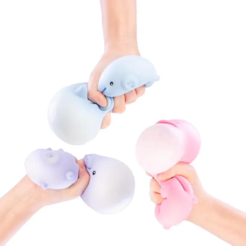 Hands squeezing pastel pig shaped squishy sensory toys in blue, pink and purple colours