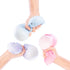 Hands squeezing pastel pig shaped squishy sensory toys in blue, pink and purple colours