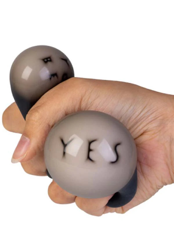 Hand squeezing a colour changing Magic Fortune Ball stress toy revealing the word YES