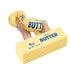 A novelty prank toy designed to look like a stick of butter, shown being squeezed by a hand. The toy is pale yellow with blue text reading '7.