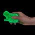 Hand squeezing green glow in the dark polyhedron animal squishy toy against black background — Adventure Awaits