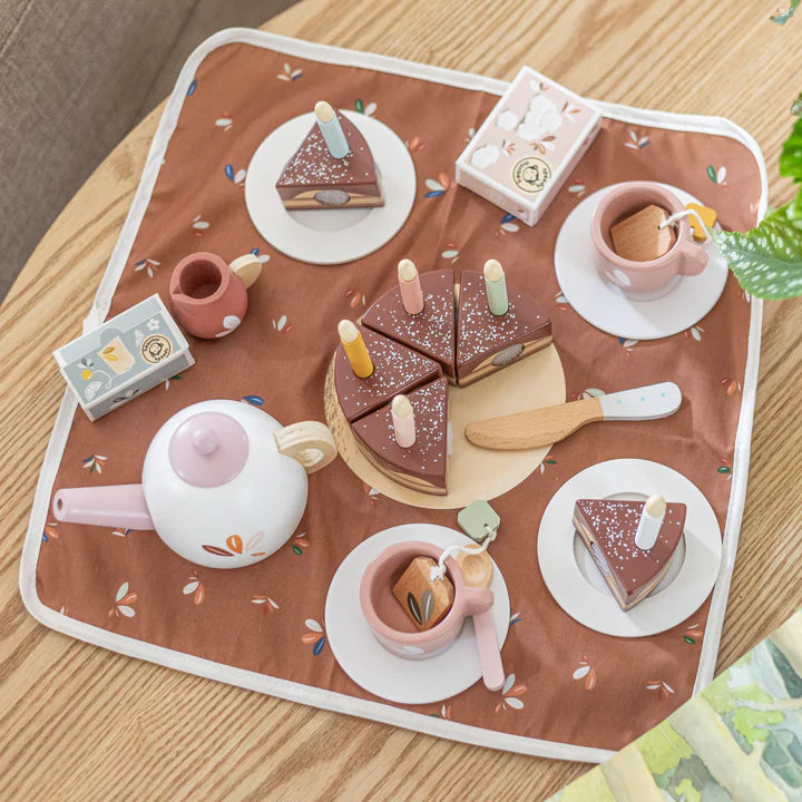 Wooden tea party set with cake, cups and teapot on a floral play mat — Adventure Awaits