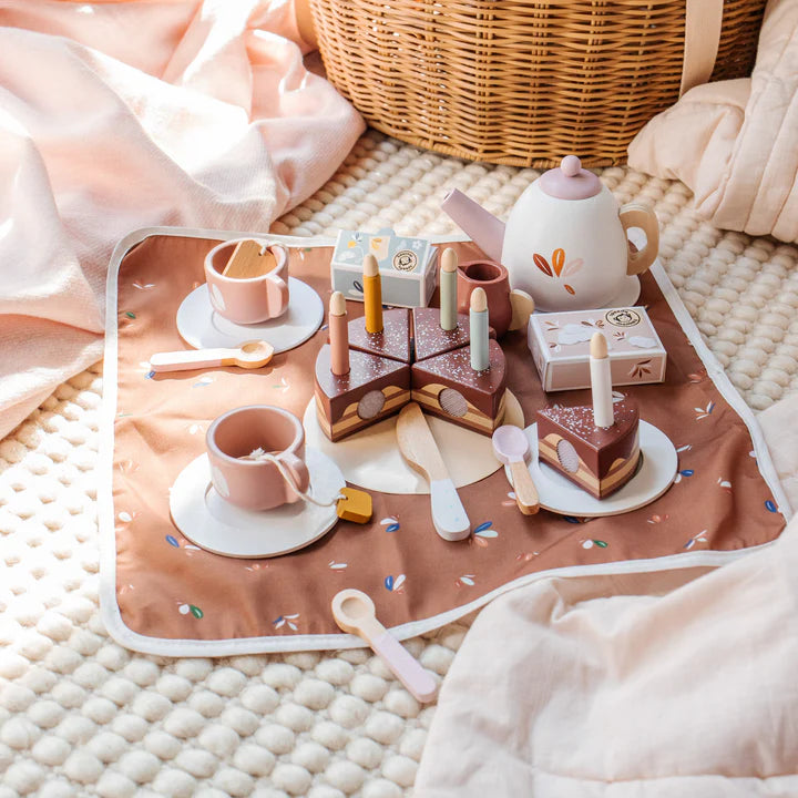 Wooden tea party set with cake slices, teapot and cups on cosy play mat — Adventure Awaits