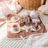 Wooden tea party set with cake slices, teapot and cups on cosy play mat — Adventure Awaits