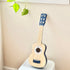 Blue wooden toy guitar with floral sound hole detail on nursery stool — Adventure Awaits