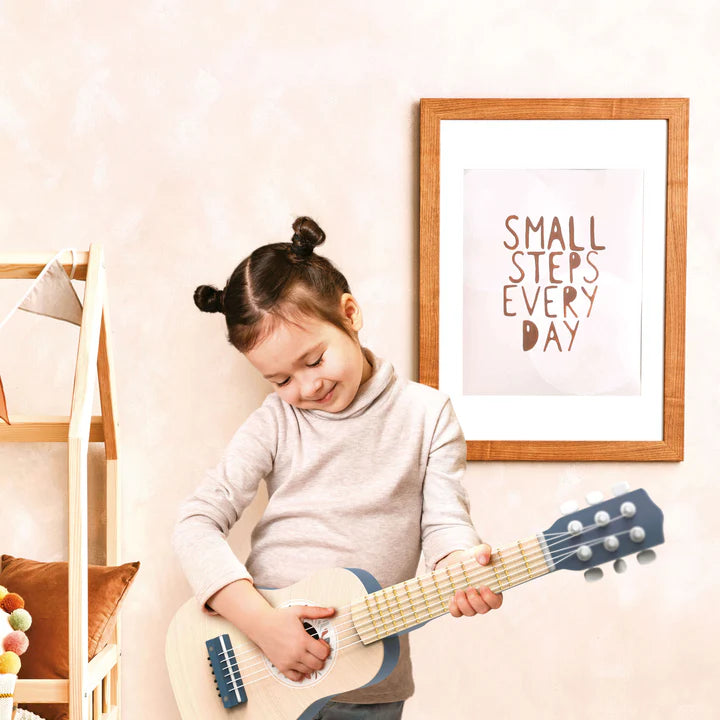 Child playing blue wooden toy guitar in nursery with small steps wall print — Adventure Awaits