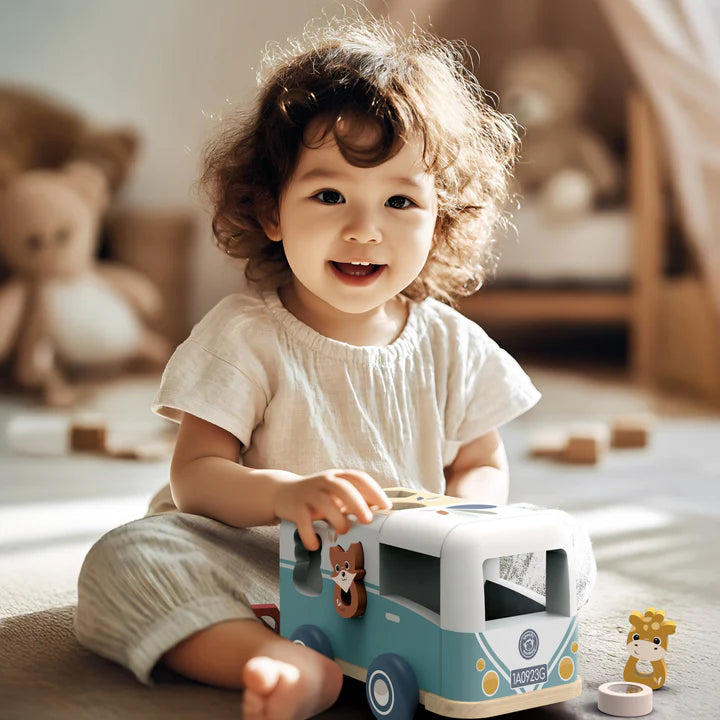 Toddler playing with blue wooden toy caravan in cosy nursery, kids travel toy — Adventure Awaits