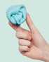 Hand holding soft blue SPEKS Blur calming focus putty against a pale blue background — Adventure Awaits