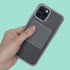 Hand holding a phone with a grey silicone fidget sticker case against a teal background