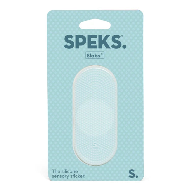 A Speks Slabs silicone sensory sticker in size S, packaged on a light blue card with a white textured oval insert visible through a clear window.