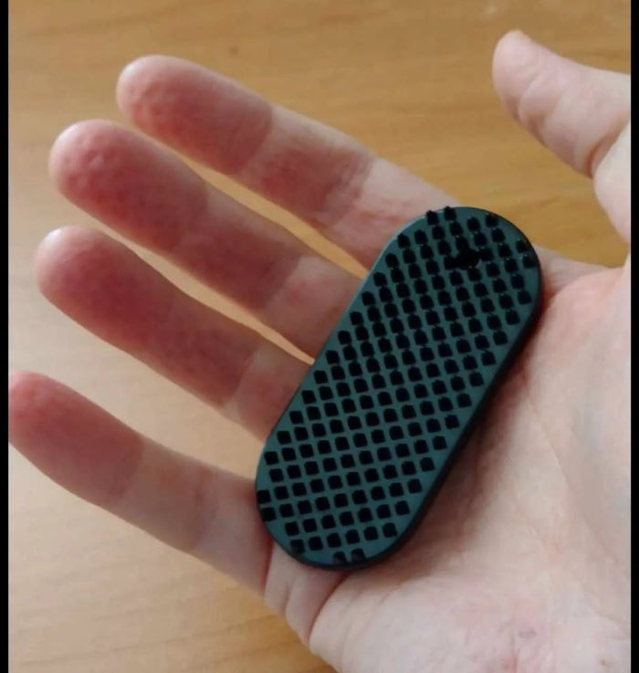 black spikeyring in palm showing indents made on fingers