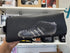 Hand holding a black football boot print toiletry bag inside a gift shop — Adventure Awaits