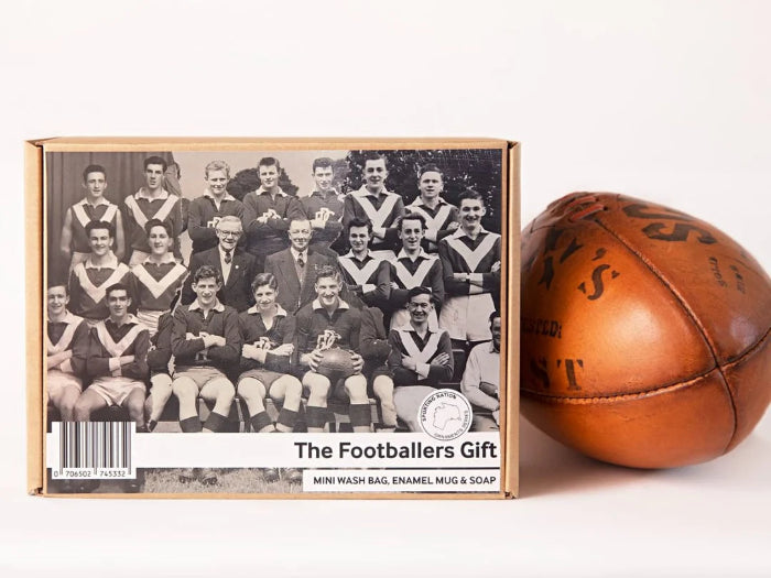 The Footballers Gift box with vintage team photo displayed beside a classic brown leather football — Adventure Awaits