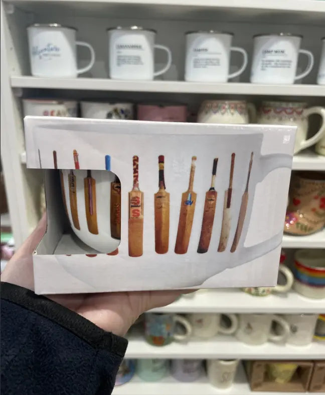 Vintage cricket bat mug in matching gift box, held in front of a shop display — Adventure Awaits