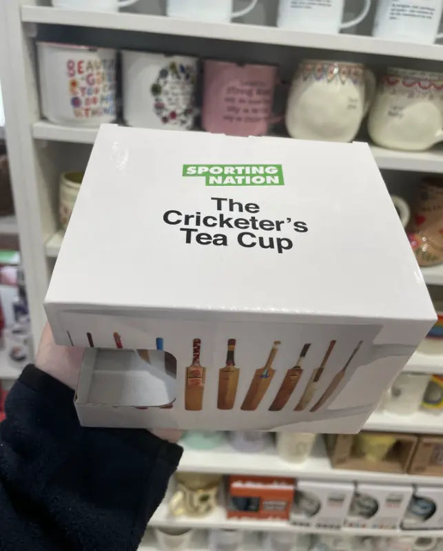 The Cricketer's Tea Cup gift box with vintage cricket bat design, held in a shop — Adventure Awaits