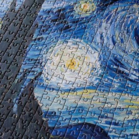 Close-up of completed Van Gogh Starry Night jigsaw puzzle showing interlocking pieces and blue brushwork — Adventure Awaits