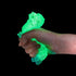 Green glowing object held in a hand against a black background