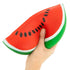 Hand squeezing The Big Squii jumbo watermelon slice squishy with red flesh, black seeds and green rind — Adventure Awaits