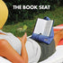 Person relaxing outdoors with The Book Seat holding an open book hands-free — Adventure Awaits