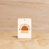 The Commonfolk Horizon Sun boho hanging air freshener with mali scent of coconut and lime on a light timber background — Adventure Awaits