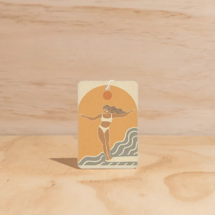The Commonfolk Surfer Girl boho hanging air freshener with Byron Bay scent of almond milk & coconut milk on a light timber background — Adventure Awaits