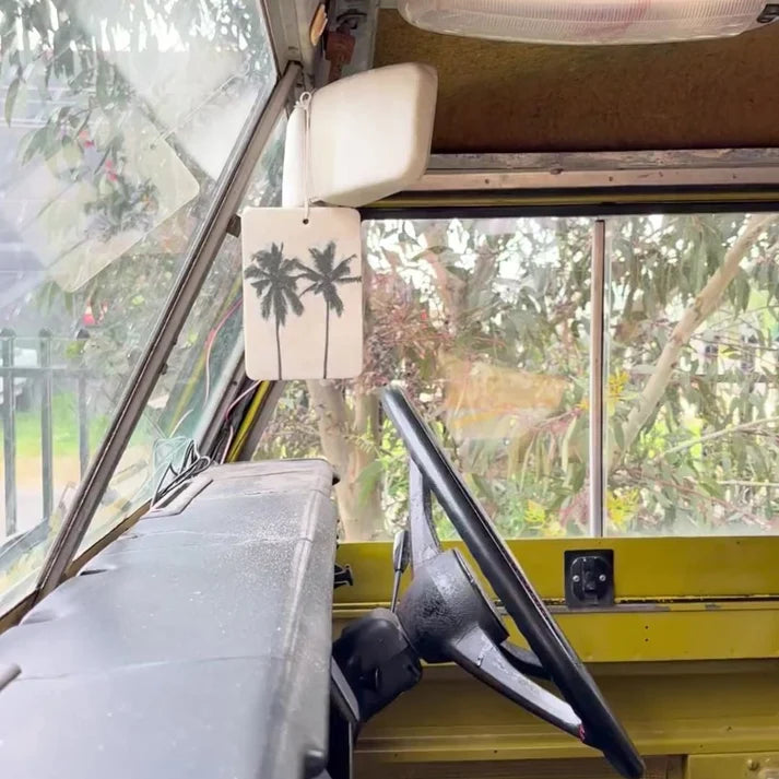 The Commonfolk twin palms boho hanging air freshener with Mali scent of coconut & lime hanging on rear view mirror — Adventure Awaits