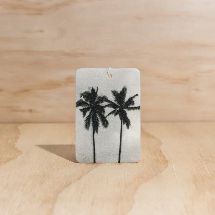 The Commonfolk twin palms boho hanging air freshener with mali scent of coconut and lime on a light timber background — Adventure Awaits