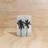 The Commonfolk twin palms boho hanging air freshener with mali scent of coconut and lime on a light timber background — Adventure Awaits