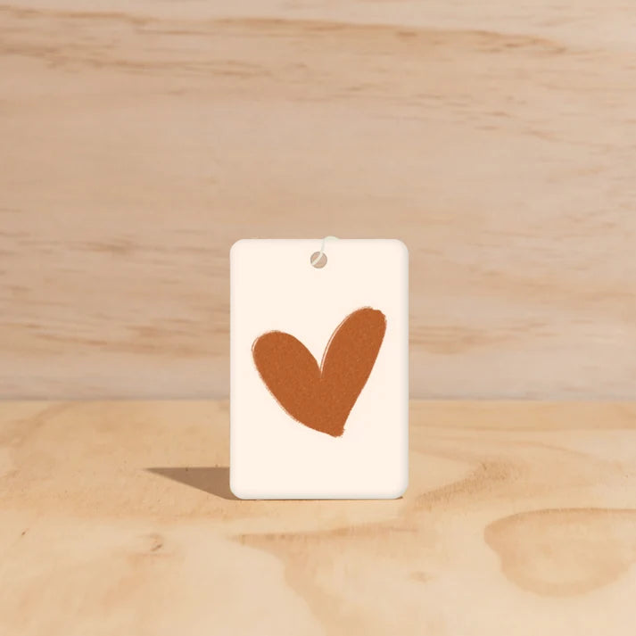 The Commonfolk Warm Heart boho hanging air freshener with Byron Bay scent of almond milk & coconut milk on a light timber background — Adventure Awaits