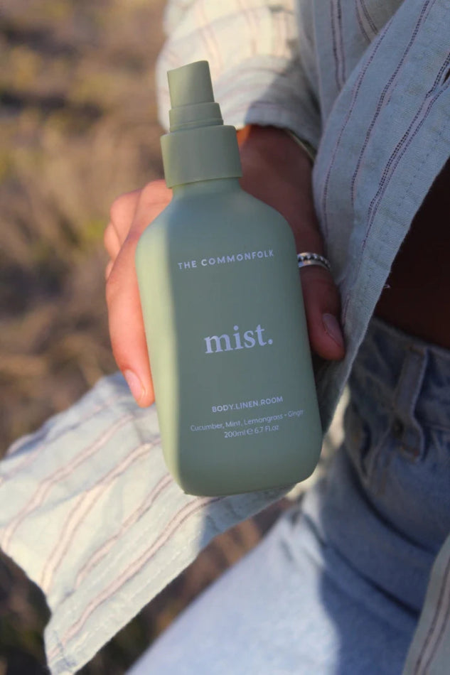 Woman holding The Commonfolk Mist body, linen and room spray in sage green with cucumber mint scent — Adventure Awaits
