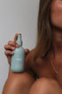 Woman holding The Commonfolk Mist body, linen and room spray in soft blue with sage, saffron & amber scent — Adventure Awaits