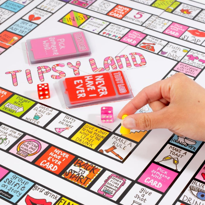 hand placing game piece on Tipsy Land board with cards and dice, colourful adult party drinking game in progress Adventure Awaits