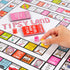 hand placing game piece on Tipsy Land board with cards and dice, colourful adult party drinking game in progress Adventure Awaits